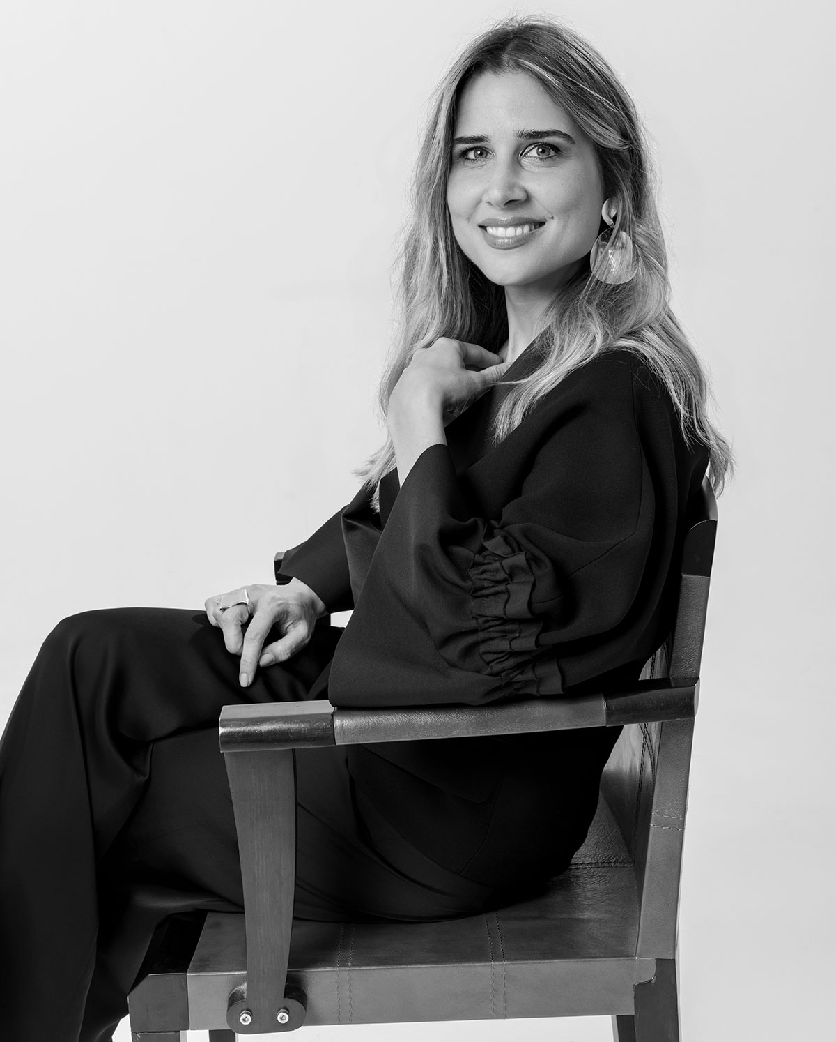 Dr. Irem Gunay, Chartered Psychologist and Existential Psychotherapist, seated, turned toward the camera and smiling